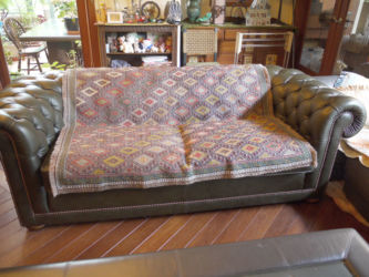 モスグリーンの革張りソファに良く合うジジムキリム。ジジムとは、平織りの上にまた別の糸を織り込ませる手法で、刺繍のように見える技法。これは、全面に施していて手間がかかっている。