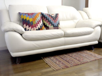 真っ白な革張りのソファにパステルカラーのクッションを置きました。差し色の黒色が利いてます。