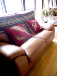 茶色のソファにはえんじ色のパッチワーククッションを合わせました。アジアの布をソファにかけて、コラボレーションを楽しみます。